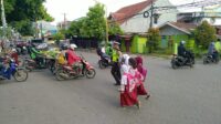 Lantas Peduli, Polisi Gowa Bantu Anak Sekolah Menyeberang Jalan